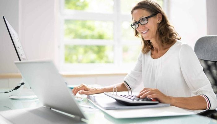 Bookkeeper looking at their computer thinking about selling their business